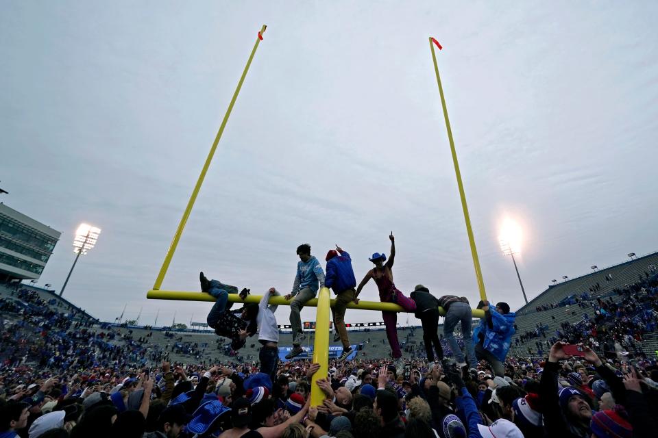 Kansas fans celebrate on the field, and some on the goal post, after a 38-33 win against OU on Saturday in Lawrence, Kan.