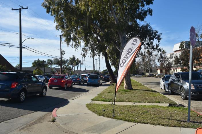 More than two dozen vehicles line up along Ninth Street in Oxnard Jan. 5 for a drive-up COVID testing center at the Oxnard Performing Arts and Convention Center.