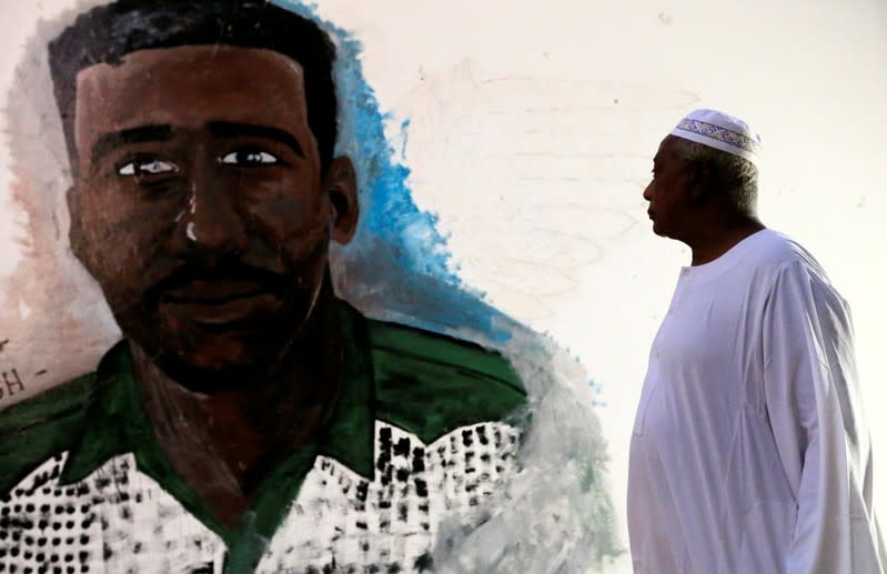 Ahmed Ali looks at a graffiti of his son inside the Nile Valley University in Atbara
