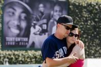 Kenny Funk, 26, embraces his girlfriend Carrie Poole, 25, at a makeshift memorial to former San Diego Padres outfielder Tony Gwynn at Petco Park in San Diego, California June 16, 2014. Gwynn, one of the greatest hitters of his generation, died on Monday at age 54 after a battle with cancer, the National Baseball Hall of Fame and Museum said. REUTERS/Sam Hodgson (UNITED STATES - Tags: SPORT BASEBALL OBITUARY)