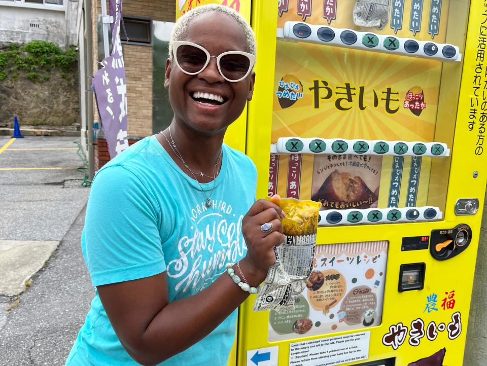 Acasia Olson in front of an Okinawan sweet potato vending machine