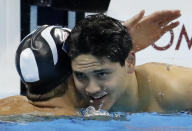 FILE - Singapore's Joseph Schooling, right, is congratulated by United States' Michael Phelps after winning the gold medal in the men's 100-meter butterfly final during the swimming competitions at the 2016 Summer Olympics, Friday, Aug. 12, 2016, in Rio de Janeiro, Brazil. Schooling, who beat Michael Phelps in the 100-meter butterfly to win Singapore's first and only Olympic gold medal at Rio de Janeiro in 2016, announced his retirement, Tuesday, April 2, 2024. (AP Photo/Dmitri Lovetsky, File)