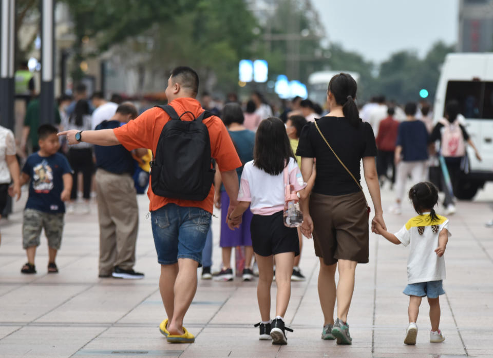 BEIJING, CHINA - 2021/07/21: Parents take their children for a walk on Wangfujing Commercial Street in Beijing.
China will establish a comprehensive support system by 2025 that helps to 