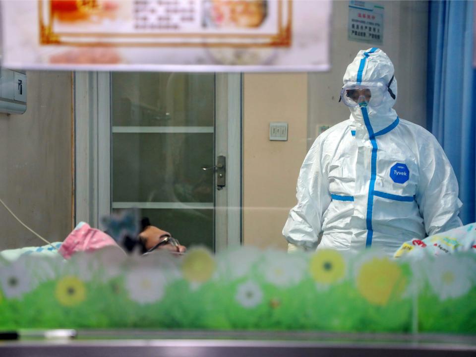 A doctor attends to a patient in an isolation ward at a hospital in Wuhan in central China's Hubei Province, Thursday, Jan. 30, 2020. China counted 170 deaths from a new virus Thursday and more countries reported infections, including some spread locally, as foreign evacuees from China's worst-hit region returned home to medical observation and even isolation. (Chinatopix via AP)