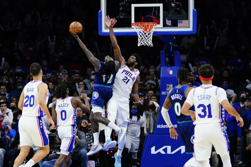 Minnesota Timberwolves' Taurean Prince, left, shoots the go-ahead basket against Philadelphia 76ers' Joel Embiid during double overtime in an NBA basketball game, Saturday, Nov. 27, 2021, in Philadelphia. (AP Photo/Matt Slocum)