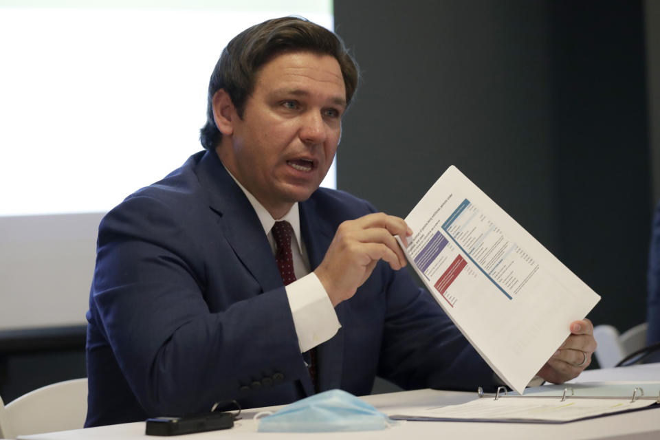 Florida Gov. Ron DeSantis holds up a document pertaining to COVID-19 during a news conference at the old Pan American Hospital, Tuesday, July 7, 2020, in Miami. (Lynne Sladky/AP)