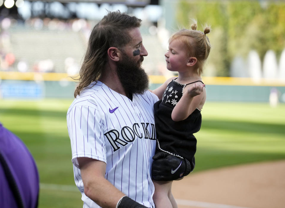 Colorado Rockies' Charlie Blackmon, left, carries his daughter in the team's ceremonial walk around the field after the Rockies' victory over the Minnesota Twins in the final regular-season baseball game Sunday, Oct. 1, 2023, in Denver. (AP Photo/David Zalubowski)