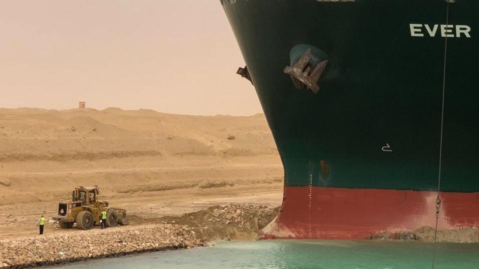 Ein Bagger versucht, das vordere Ende des Containerschiffs Ever Given zu befreien.