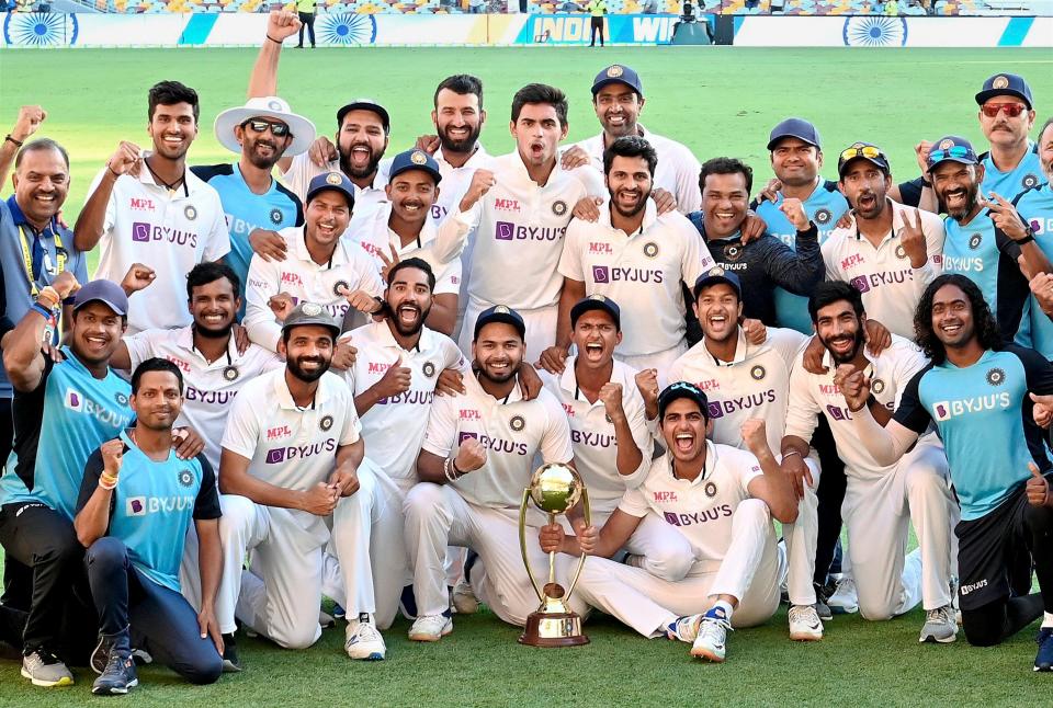 Indian players pose with the winning trophy after defeating Australia by three wickets on the final day of the fourth cricket test match at the Gabba, Brisbane, Australia, on Tuesday, 19 January 2021. India won the four test series 2-1.