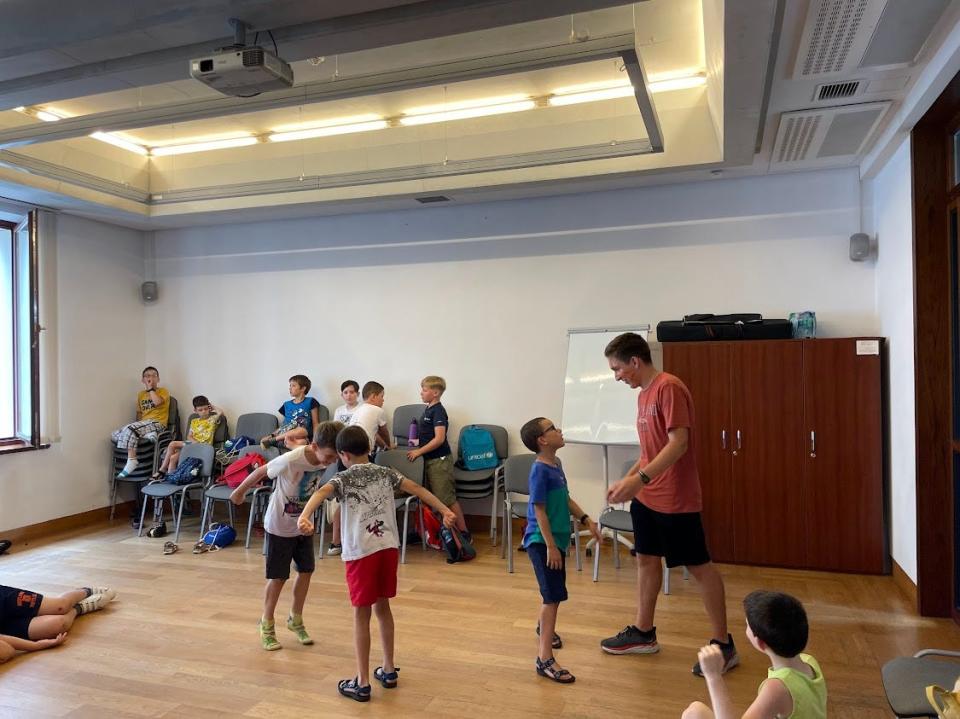 Noah Bock (standing) interacts with children at the English immersion camp in Poland.