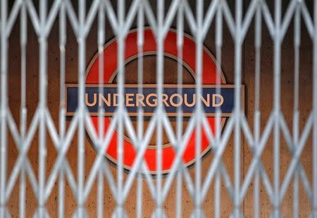 FILE PHOTO: A London Underground sign is seen behind a locked gate, in central London December 26, 2010. REUTERS/Luke MacGregor/File Photo