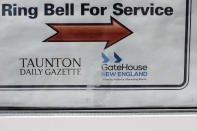 In this Monday, Aug. 5, 2019 photo a GateHouse New England logo appears on a door to the Taunton Daily Gazette newspaper's offices, in Taunton, Mass. The newspaper is published by GateHouse Media New England, a division of GateHouse Media Inc. On Monday, GateHouse Media, a chain backed by an investment firm, announced that it is buying USA Today owner Gannett Co. (AP Photo/Steven Senne)