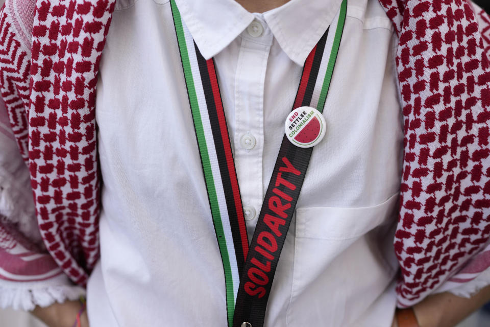 FILE - A protester wearing a pin with a symbol of a watermelon participates in a demonstration calling for a ceasefire in the Israel-Hamas war at the COP28 U.N. Climate Summit, Sunday, Dec. 3, 2023, in Dubai, United Arab Emirates. Over the past three months, on banners and T-shirts and balloons and social media posts, one piece of imagery has emerged around the world in protests against the Israel-Hamas war: the watermelon. The fruit has increasingly come to be recognized as a symbol of Palestinian resistance and a global sign of solidarity. (AP Photo/Rafiq Maqbool, File)