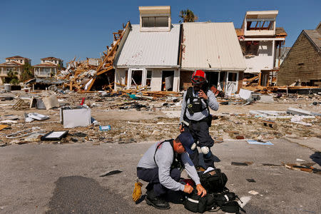 Members of search and rescue crew are seen next to property damaged by Hurricane Michael in Mexico Beach, Florida, U.S. October 11, 2018. REUTERS/Jonathan Bachman/Files