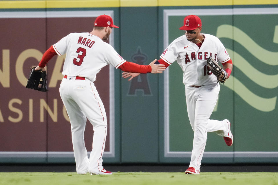 Los Angeles Angels right fielder Taylor Ward (3) and center fielder Juan Lagares (19) celebrate after Lagares caught a fly ball hit by Boston Red Sox shortstop Xander Bogaerts (2) during the sixth inning of a baseball game Tuesday, July 6, 2021, in Anaheim, Calif. (AP Photo/Ashley Landis)