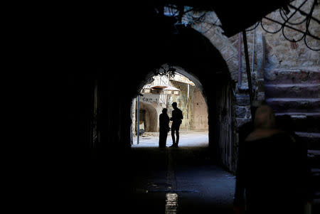 Palestinians stand in the old city of the West Bank city of Hebron July 7, 2017. REUTERS/Ammar Awad