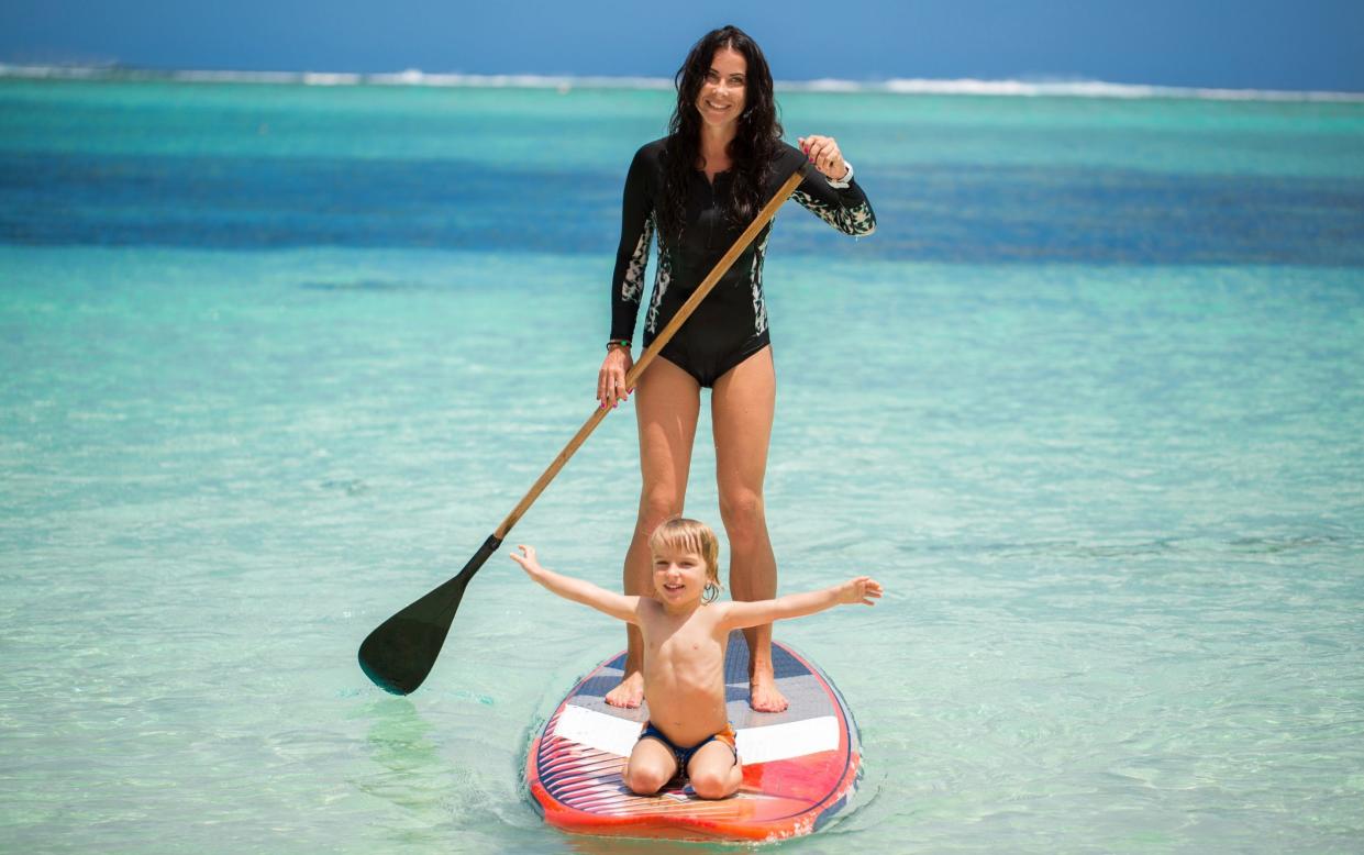 Mother and son surfing in Mauritius - Shuttershock