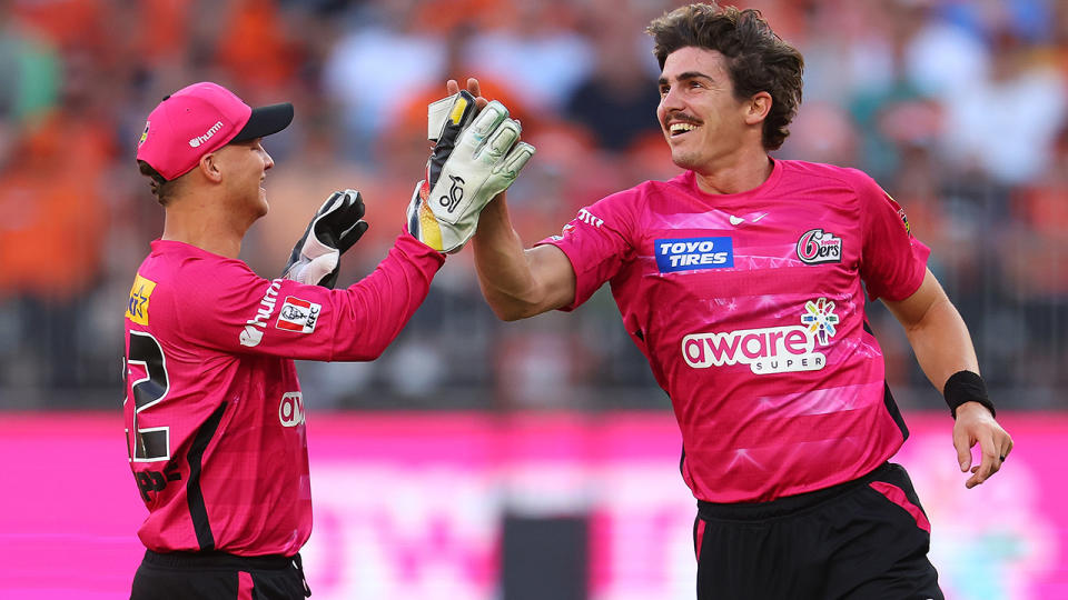 Sean Abbott celebrates a wicket for the Sydney Sixers with wicketkeeper Josh Phillipe.