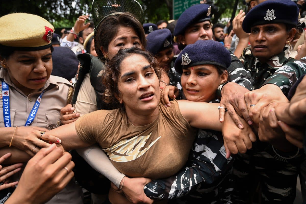 Indian wrestler Vinesh Phogat (centre) is detained by the police while attempting to march to India’s new parliament (AFP via Getty Images)