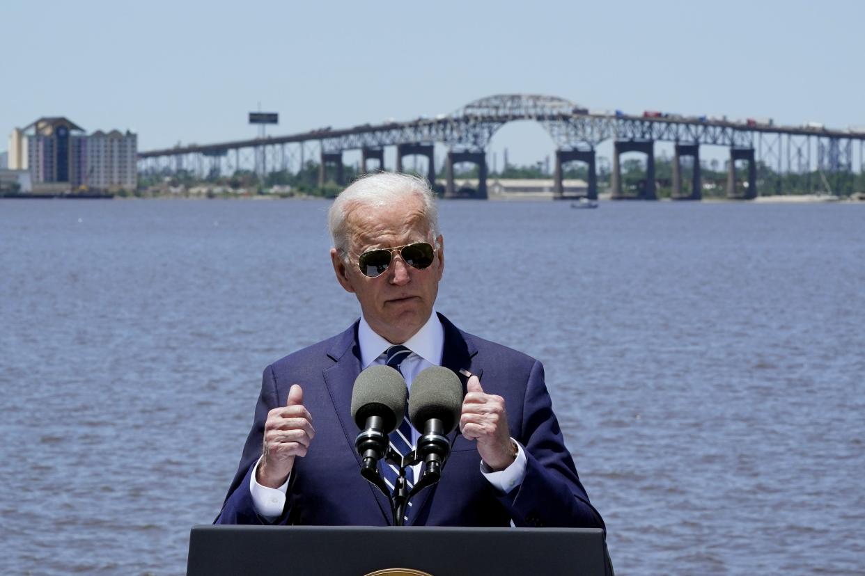 President Biden speaks with the Interstate 10 Calcasieu River Bridge behind him Thursday in Lake Charles, La. 