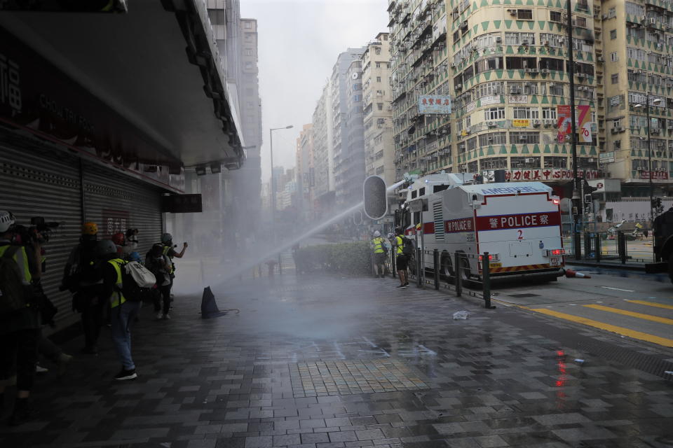 Police use water cannon to chase away protestors in Hong Kong, Sunday, Oct. 20, 2019. Hong Kong protesters again flooded streets on Sunday, ignoring a police ban on the rally and setting up barricades amid tear gas and firebombs. (AP Photo/Kin Cheung)