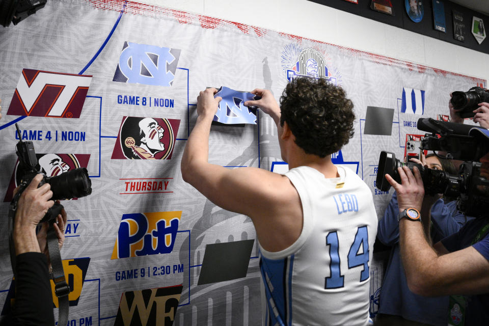 North Carolina guard Creighton Lebo places a North Carolina sticker on the bracket following an NCAA college basketball game in the quarterfinal round of the Atlantic Coast Conference tournament, Thursday, March 14, 2024, in Washington. North Carolina won 92-67. (AP Photo/Nick Wass)