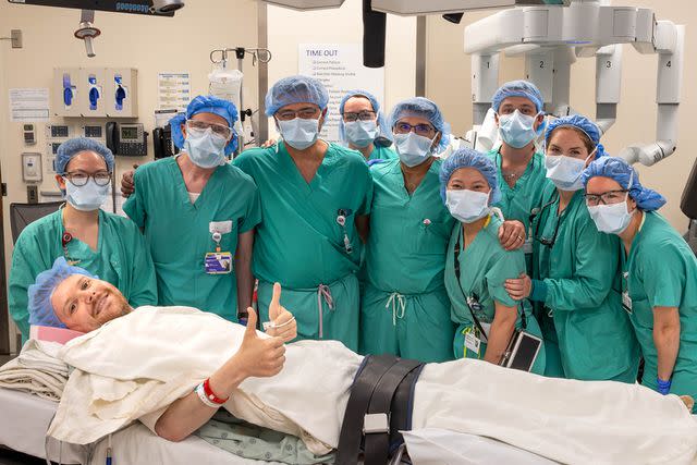 <p>Jose M. Osorio/Northwestern Medicine</p> John Nicholas poses in the ER with his surgery team at Northwestern Medicine.