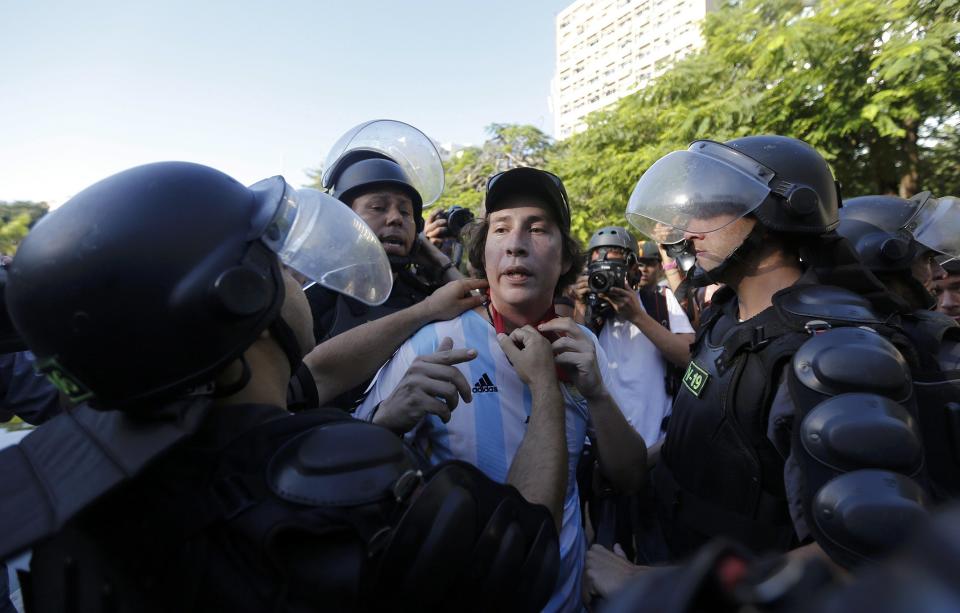 A demonstrator wears an Argentina national team jersey as he argues with policemen before the 2014 World Cup final match between Argentina and Germany in Rio de Janeiro, July 13, 2014. REUTERS/Marco Bello (BRAZIL - Tags: POLITICS SOCCER CRIME LAW SPORT CIVIL UNREST WORLD CUP)