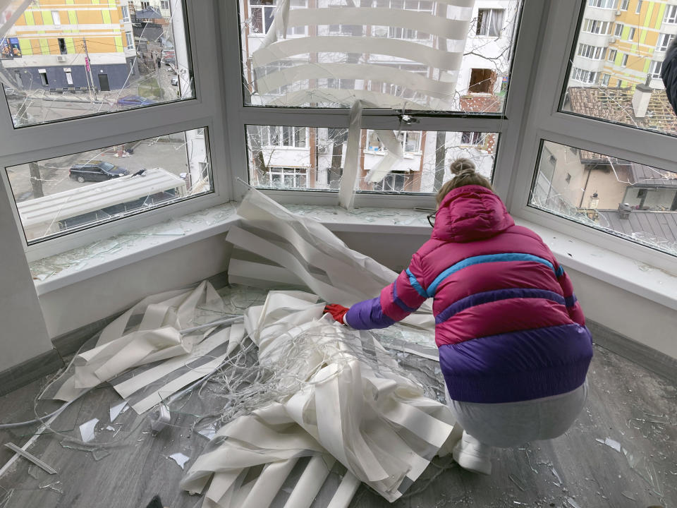 Oksana Lyul’ka collects broken glass in her war-damaged apartment in Irpin, Ukraine, on Monday, April 11, 2022. Heartened by Russia’s withdrawal from the capital region, some residents have been coming to what’s left of home. (AP Photo/Cara Anna)