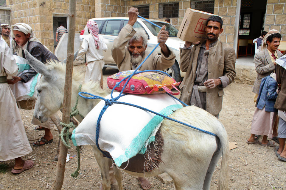 A father carries home his monthly ration of food items provided by Mercy Corps through its voucher system working with local food suppliers in Haymah Kharijiyah, Sanaa Governorate.&nbsp;