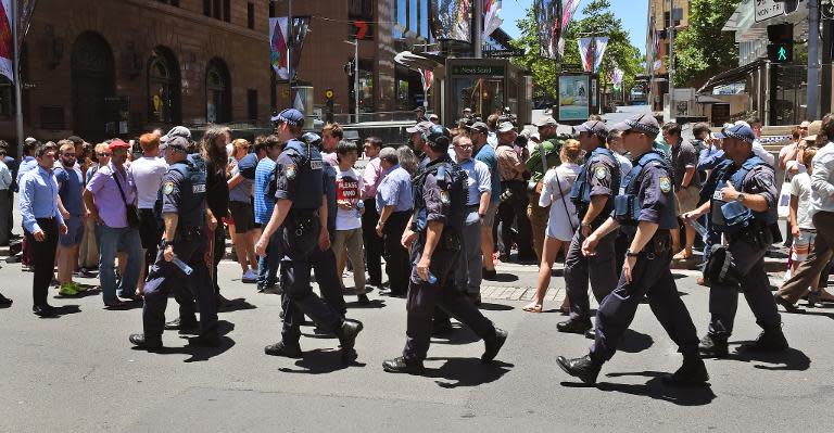 Police walk through Martin Place as spectators look on