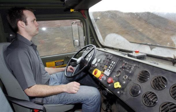 Oshkosh Corporation engineer Noah Zych sits with his hands in his lap while the Terramax autonomous truck drives itself around a test course outside of Pittsburgh, Pennsylvania March 1, 2012. The robotic truck, which can drive and navigate for itself, is being studied by the U.S. military as a possible cargo hauling system for the Marine Corps and the Army.
