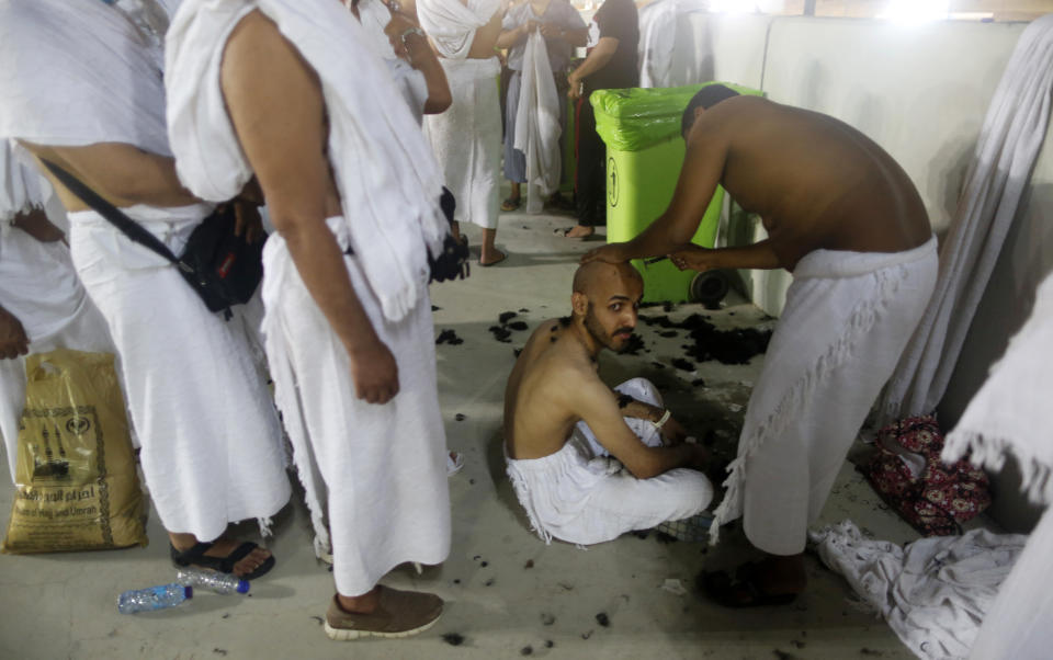 Muslim pilgrims line up as they wait to shave their heads for free after they cast stones at a pillar symbolizing the stoning of Satan, in a ritual called "Jamarat," the last rite of the annual hajj, on the first day of Eid al-Adha, in Mina near the holy city of Mecca, Saudi Arabia, Sunday, Aug. 11, 2019. The hajj is required of all Muslims to perform once in their lifetime if they are financially and physically able. (AP Photo/Amr Nabil)