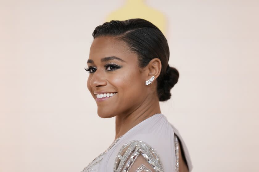 Ariana DeBose smiles in a sparkly dress against a cream background