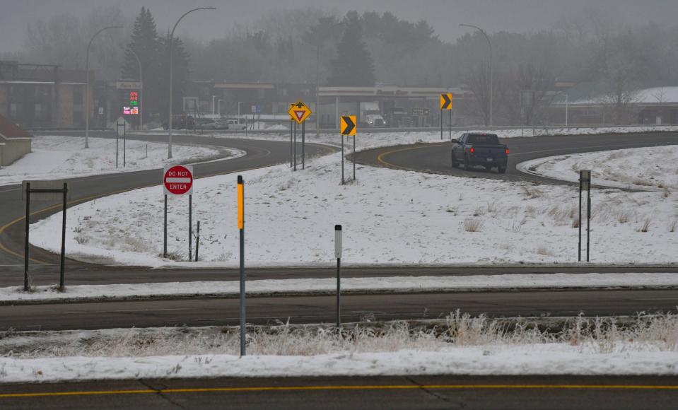 Traffic moves through heavy fog at the intersection of Highways 10 and 23 Thursday, Jan. 7, 2021, in St. Cloud.   