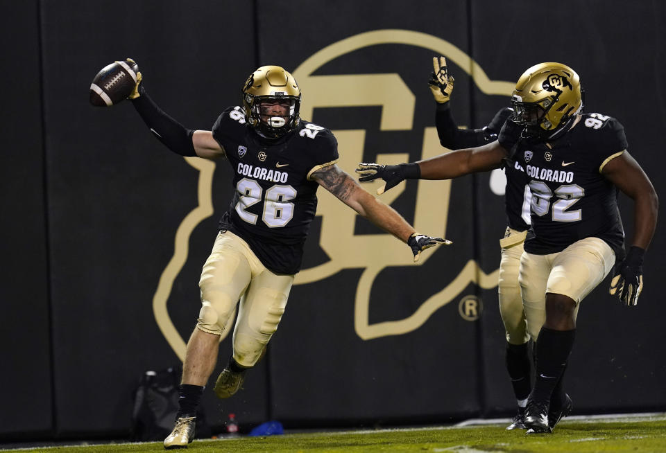 Colorado linebacker Carson Wells, left, celebrates his interception of a pass with defensive tackle Lloyd Murray Jr. in the first half of an NCAA college football game against UCLA, Saturday, Nov. 7, 2020, in Boulder, Colo. (AP Photo/David Zalubowski)