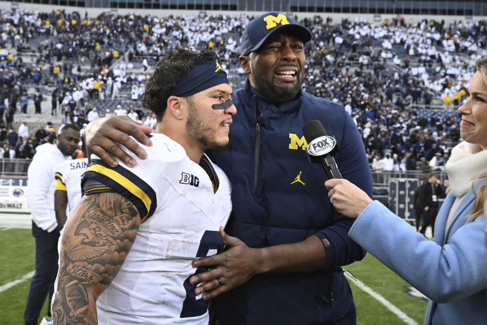 Michigan acting head coach Sherrone Moore and running back Blake Corum (2) celebrate a 24-15 win over Penn State following an NCAA college football game, Saturday, Nov. 11, 2023, in State College, Pa. (AP Photo/Barry Reeger)