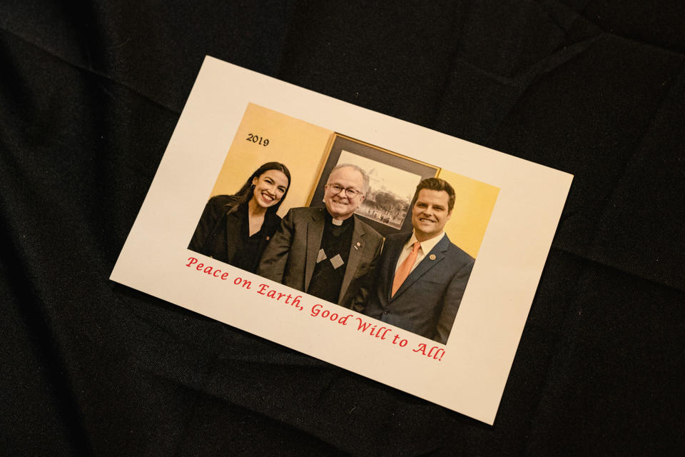 Alexandria Ocasio-Cortez and Matt Gaetz pose alongside former House Chaplain Father Patrick Conroy for Conroy's 2019 Christmas card<span class="copyright">Shuran Huang for TIME</span>