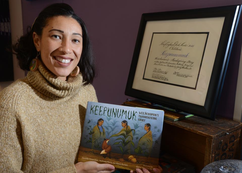 Cape Cod author Danielle Greendeer holds a copy of her book "Keepunumuk" and a framed copy of her 2022 New England Book Award for children's books.