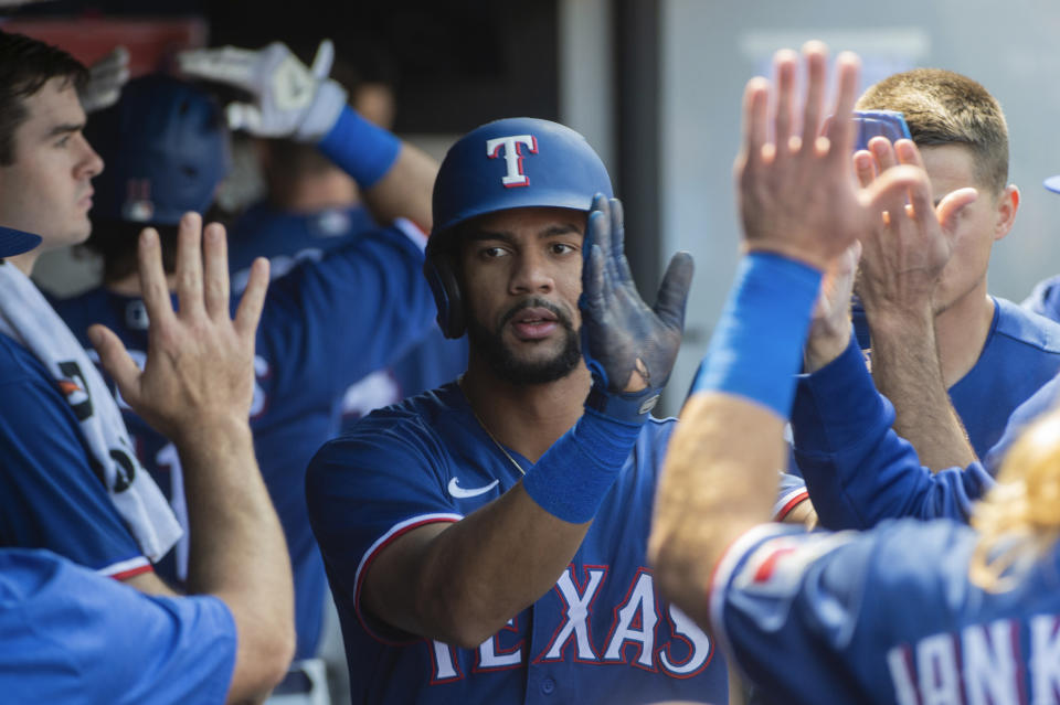 Texas Rangers' Leody Taveras is congratulated by his teammates after scoring on a double by Josh Smith during the second inning of a baseball game in Cleveland, Sunday, Sept. 17, 2023. (AP Photo/Phil Long)