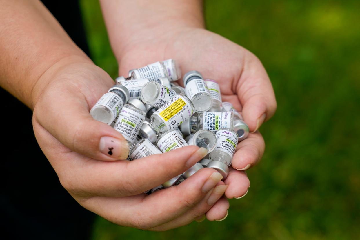 Leo Figgs, a transgender teenager, holds in his hands three years worth of empty testosterone vials he’s been collecting on Saturday, July 29, 2023, in Lexington, Ky.