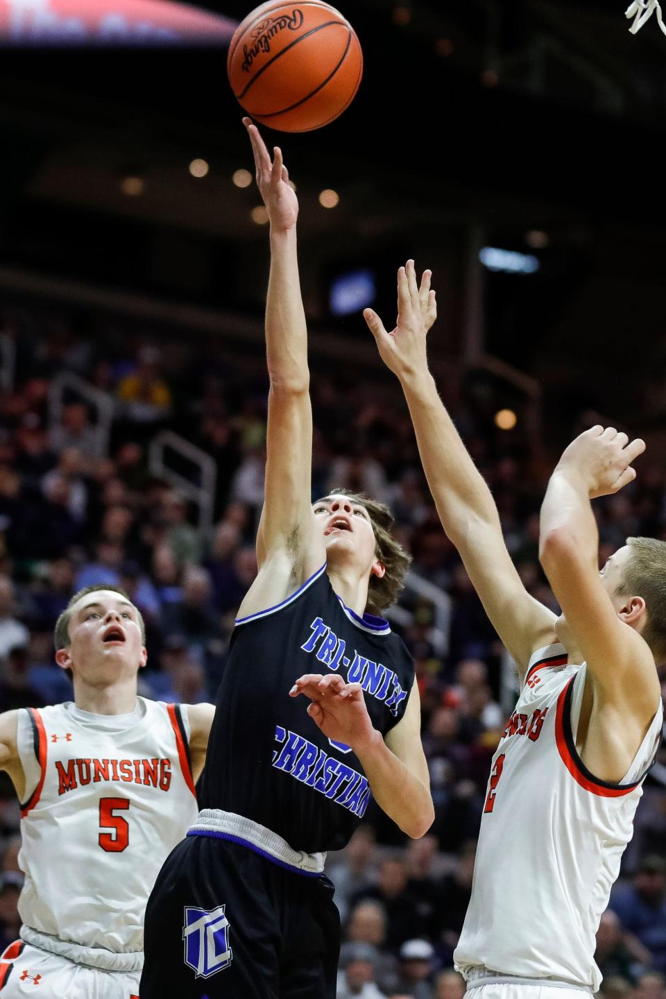 Wyoming Tri-unity Christian guard Jordan VanKlompenberg (3) makes a layup against Munising forward Carson Kienitz (2) during the second half of the MHSAA boys Division 4 final at Breslin Center in East Lansing on Saturday, March 25, 2023.