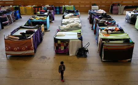 FILE PHOTO - A migrant child walks at the sports hall of the Jane-Addams high school which has been transformed into a refugee shelter in Berlin's Hohenschoenhausen district, Germany, February 2, 2016 REUTERS/Fabrizio Bensch/File Photo