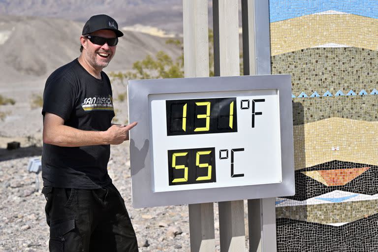 Un visitante posa frente a un termómetro digital no oficial que marca 131°F (55°C) en el Centro de Visitantes de Furnace Creek en el Parque Nacional del Valle de la Muerte, el 16 de julio de 2023. 
