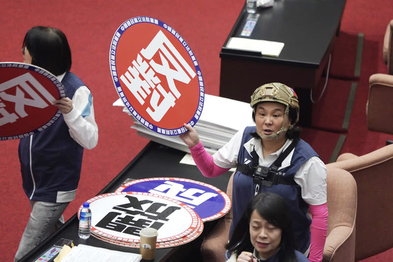 立院上演朝野表決戰  陳玉珍全副武裝 立法院會17日處理藍白所提國會改革相關法案，朝野 上演表決大戰。圖為國民黨立委陳玉珍（後右）全副 武裝、在胸前配戴GoPro，並舉牌表達立場。 中央社記者徐肇昌攝  113年5月17日 