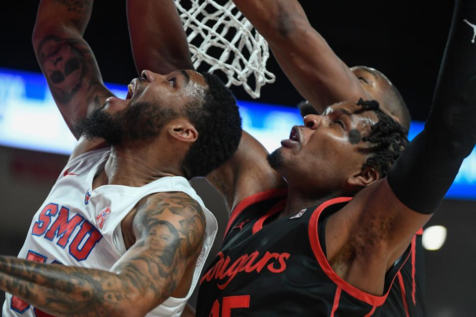 SMU forward Marcus Weathers attempts to layup against Houston center Josh Carlton during the first half of an NCAA college basketball game Sunday, Feb. 27, 2022, in Houston. (AP Photo/Justin Rex)