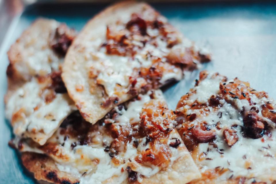 Flammenkuchen (a pizza made with caramelized onions and bacon) will be one of the several German dishes featured at The Second Line's "Oktoberfest" pop-up running September 1 - October 3, 2023.