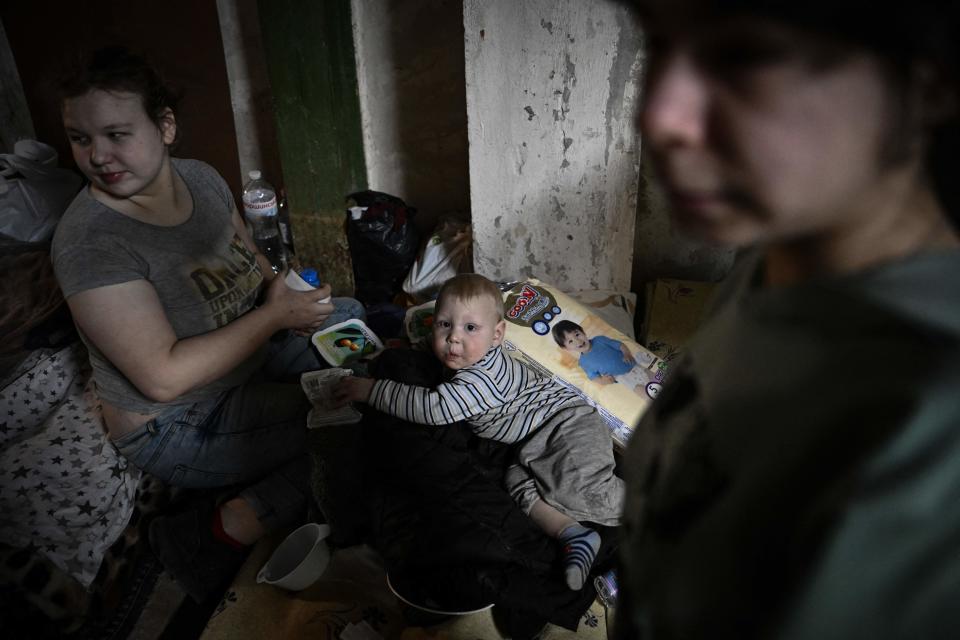 A women look after her toddler at the pediatrics center after the unit was moved to the basement of the hospital which is being used as a bomb shelter, in Kyiv on February 28, 2022. - The Russian army said on February 28, 2022, that Ukrainian civilians could 