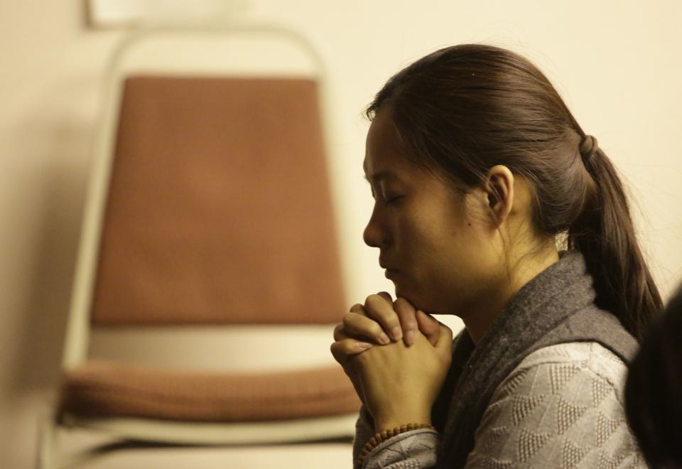 A relative of a passenger onboard Malaysia Airlines Flight MH370 prays at a praying room in Beijing