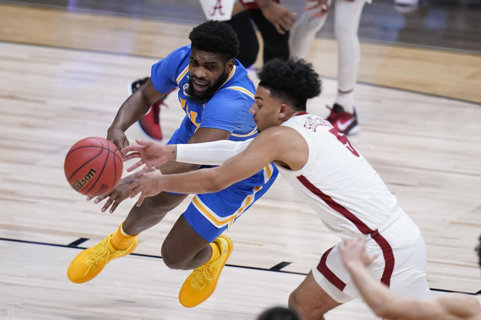 UCLA forward Cody Riley (2) and Alabama guard Jaden Shackelford (5) chase a loose ball in the first half of a Sweet 16 game in the NCAA men's college basketball tournament at Hinkle Fieldhouse in Indianapolis, Sunday, March 28, 2021. (AP Photo/Michael Conroy)